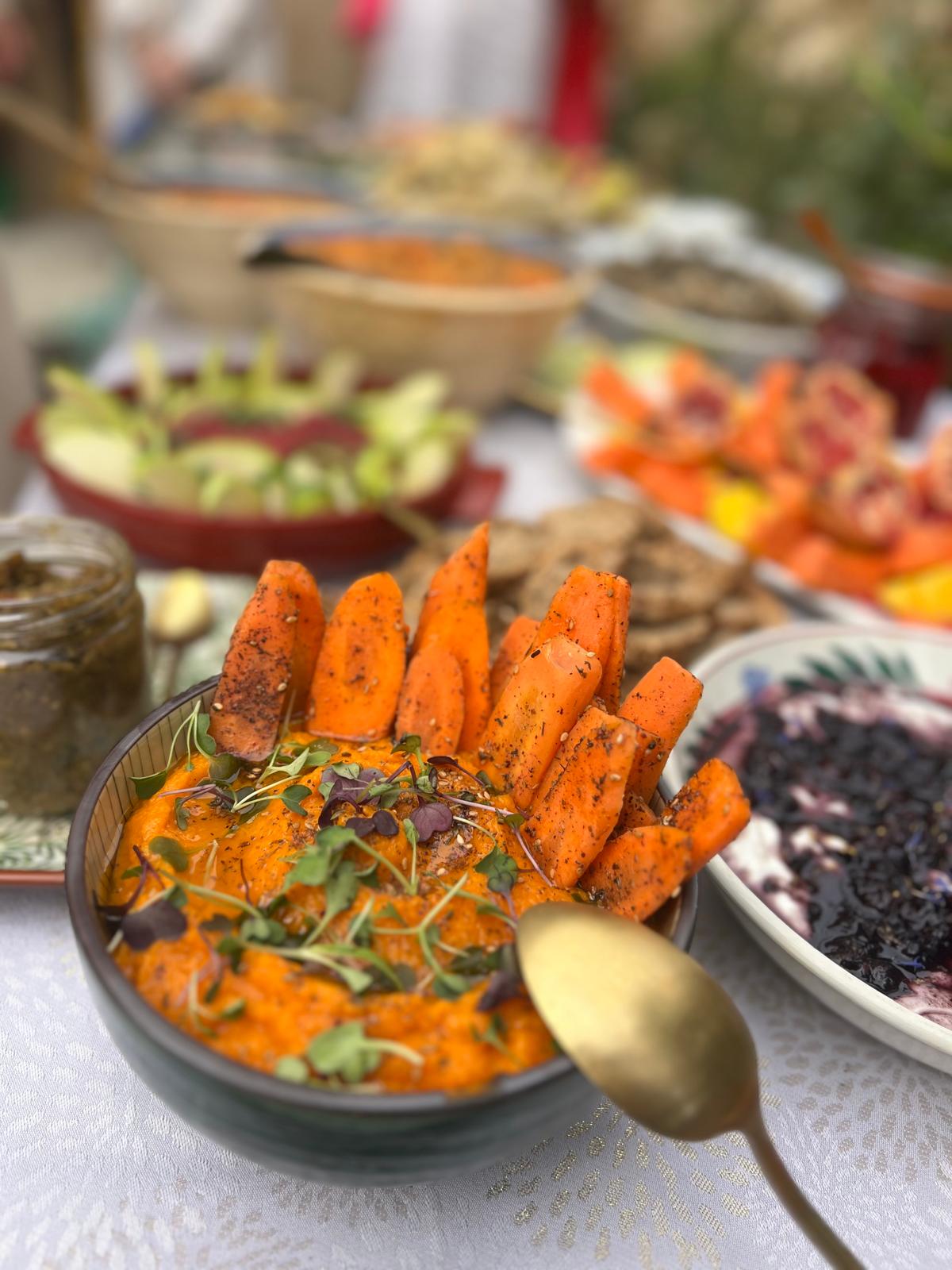 Spiced carrot dip with roasted carrots at a garden lunch table