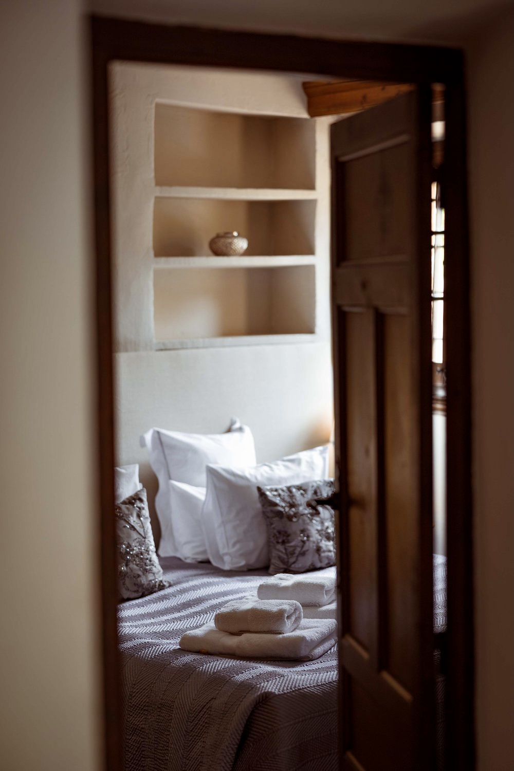 Guest room glimpsed through an old wooden door