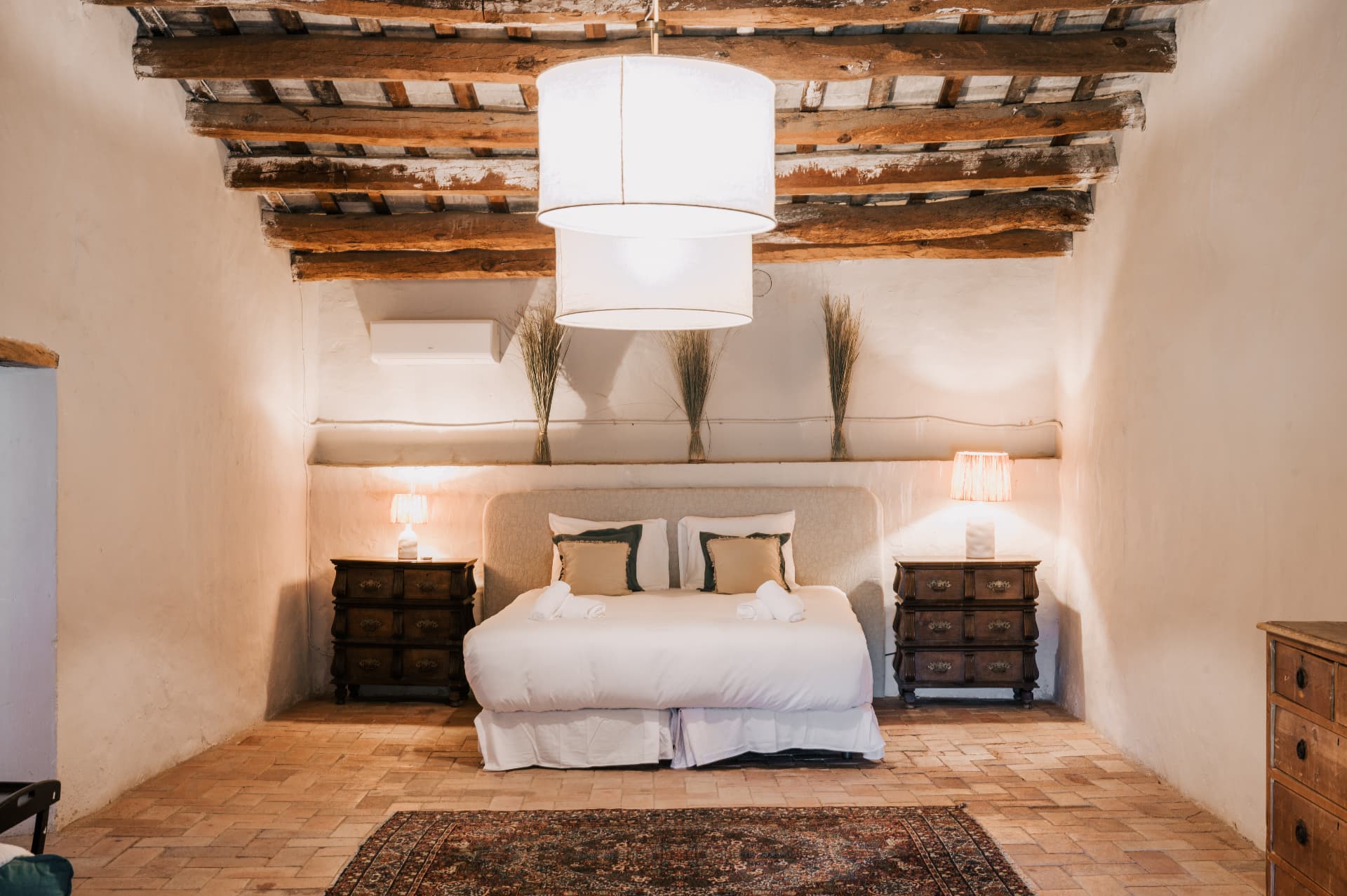 Bedroom under original timber beams with terracotta floors