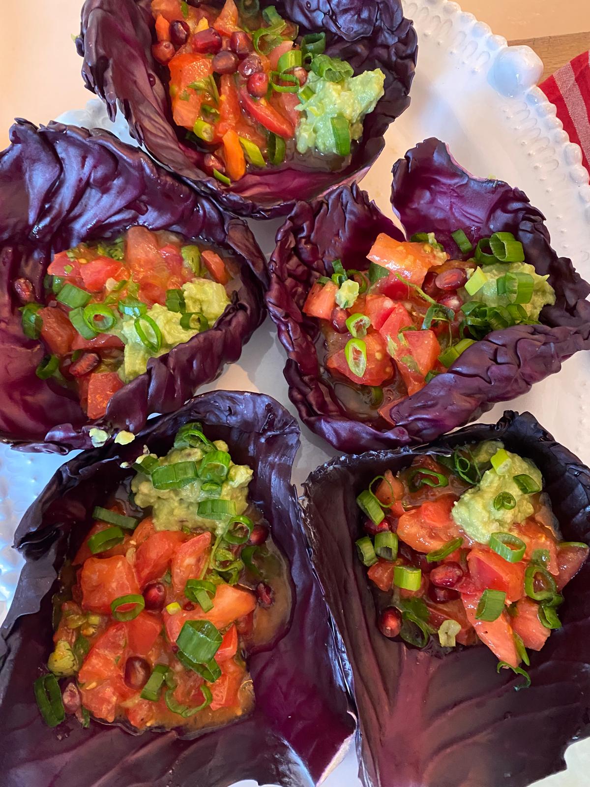 Red cabbage cups filled with tomato, avocado and pomegranate